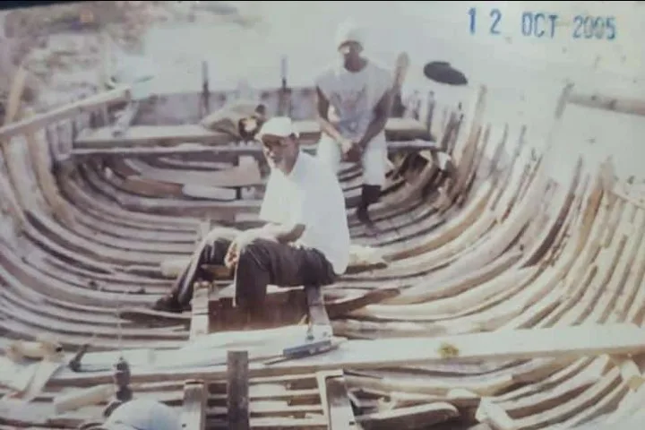 Boat builders at work inside a wooden hull, 2005